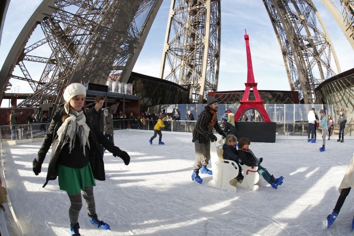 Tourists ice skate on the Eiffel Tower's skating rink in Paris December 9, 2014. The skating rink, located on the first level of the Eiffel Tower, opens to the public as part of the Christmas holiday season.   REUTERS/Charles Platiau (FRANCE - Tags: SOCIETY) - RTR4H9V3
